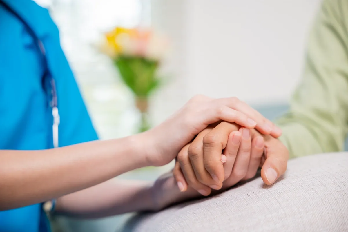 Caring nurse helping elderly old man at care facility